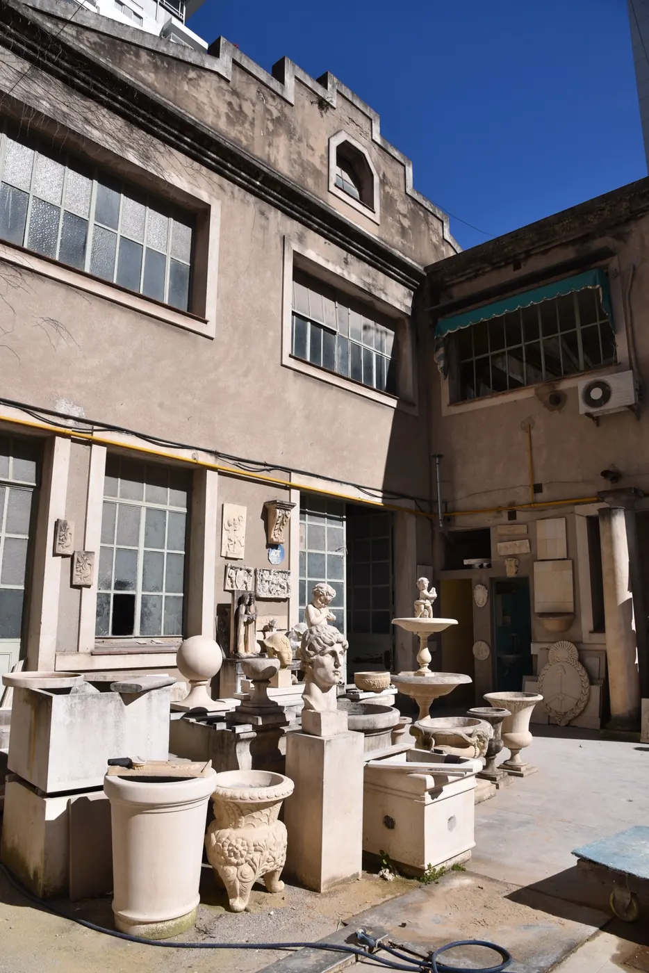 Patio del taller histórico de Martineau con fuentes, ánforas y esculturas