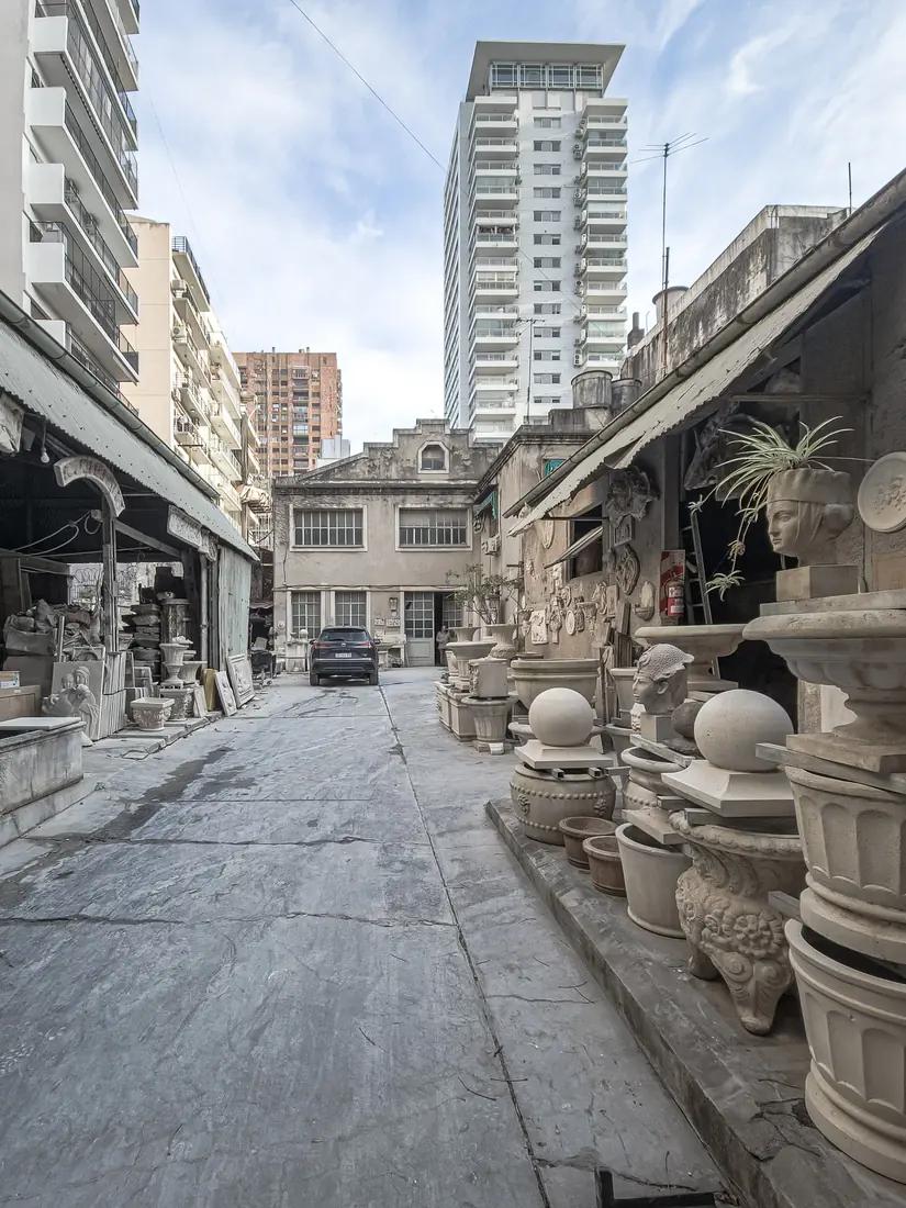 Patio del taller con maceteros, ánforas y esculturas de piedra reconstituida